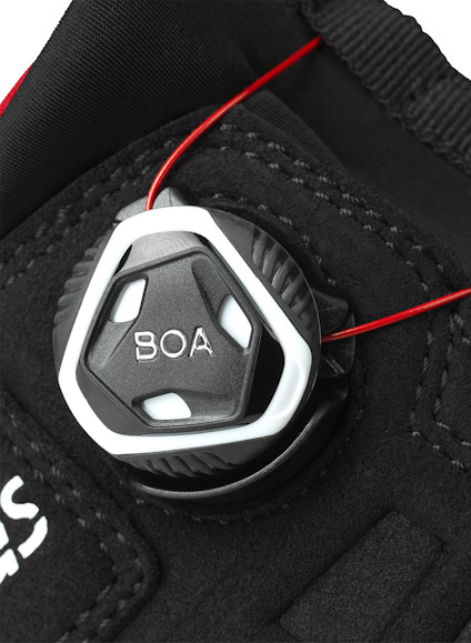 Självhjulande BOA-stängning med svart och vitt reglage och röd tråd.