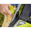 En hand justerar reglaget på en grön och svart gräsklippare av märket RYOBI med synlig etikett och logotyp.