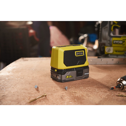 Laserpassare från Ryobi med grönt och svart hölje, placerad på en bordsyta.