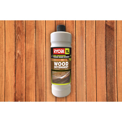 Flaska med Ryobi 1L wood detergent stående mot en bakgrund av trägolvplankor.