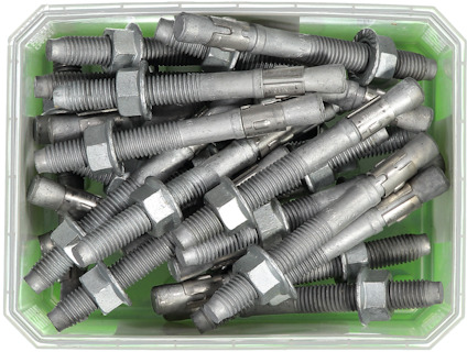 Metallbultar med muttrar i en grön plastlåda.