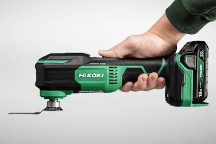 En person håller i ett batteridrivet, grönt och svart multiverktyg med texten "HIKOKI".