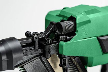 Grön och svart handhållen elektrisk häftpistol med laddad häftklammer.