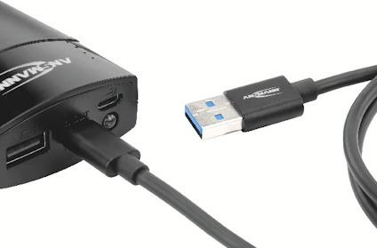 USB-kabel ansluten till en port på en svart elektronisk enhet.